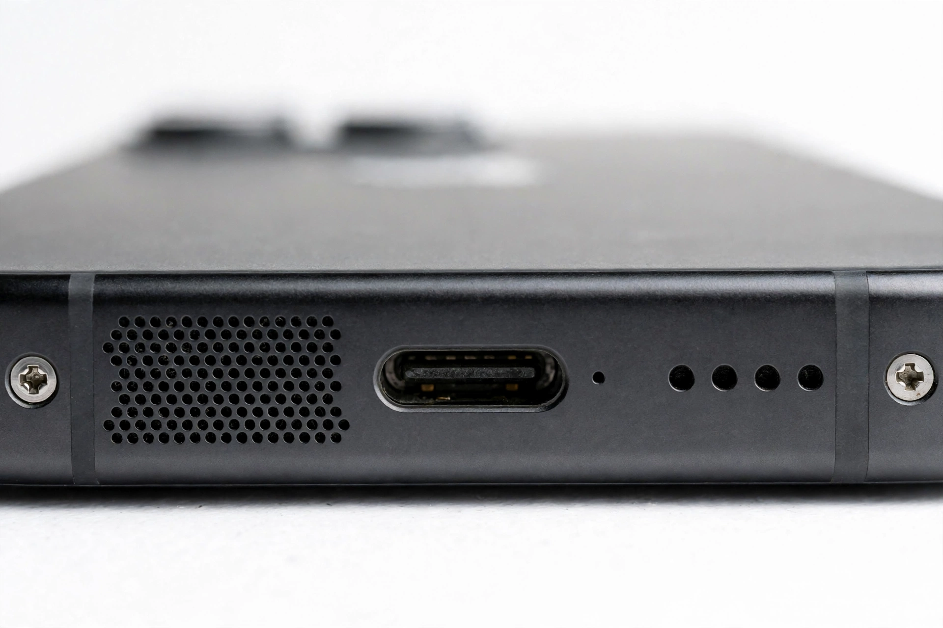 Macro close-up of a smartphone bottom edge speaker grille