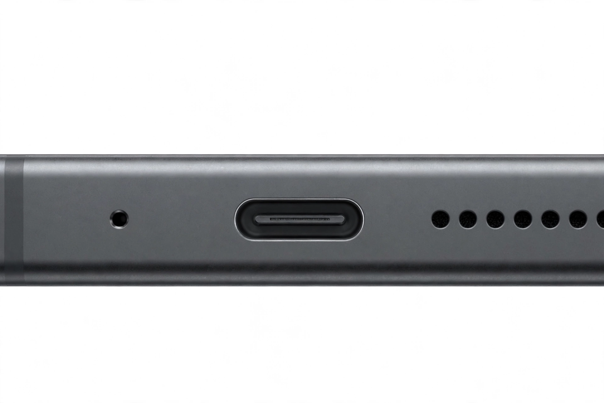 Macro close-up of a smartphone bottom edge showing the microphone pinhole next to the charging port
