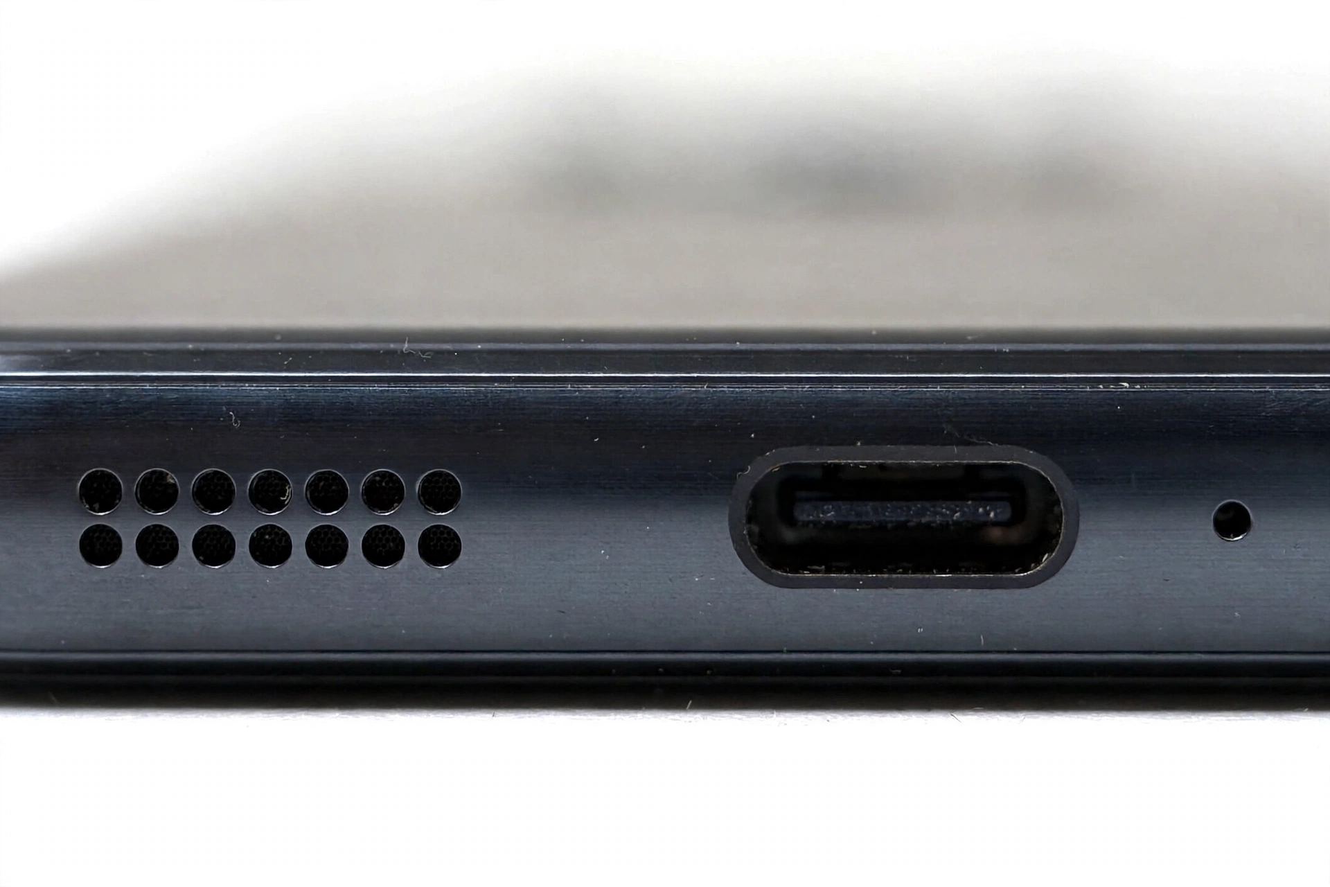 Macro close-up of smartphone bottom edge speaker grille