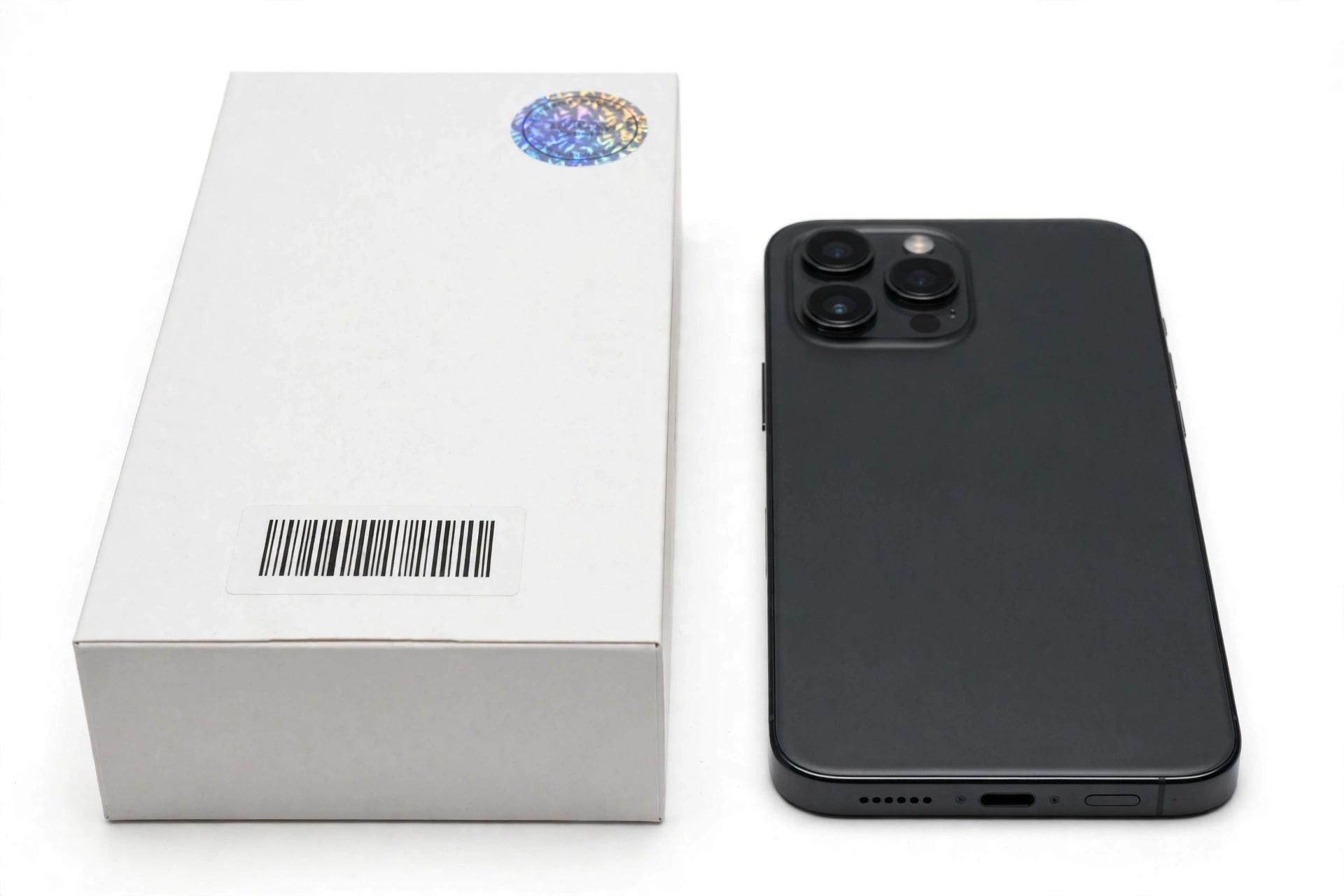 Smartphone next to its retail box with verification seal and serial number label