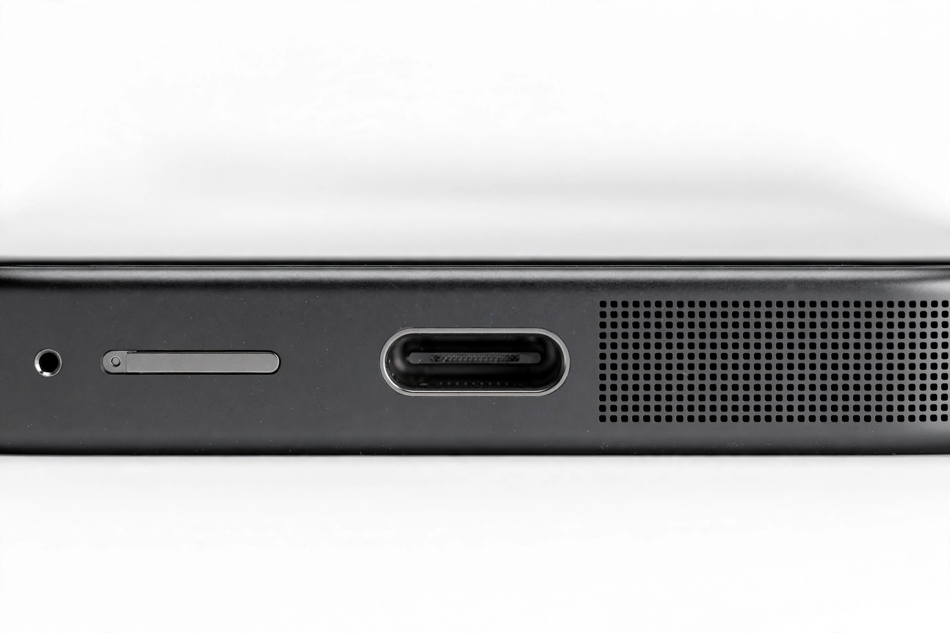 Close-up of a smartphone bottom edge showing the speaker grille