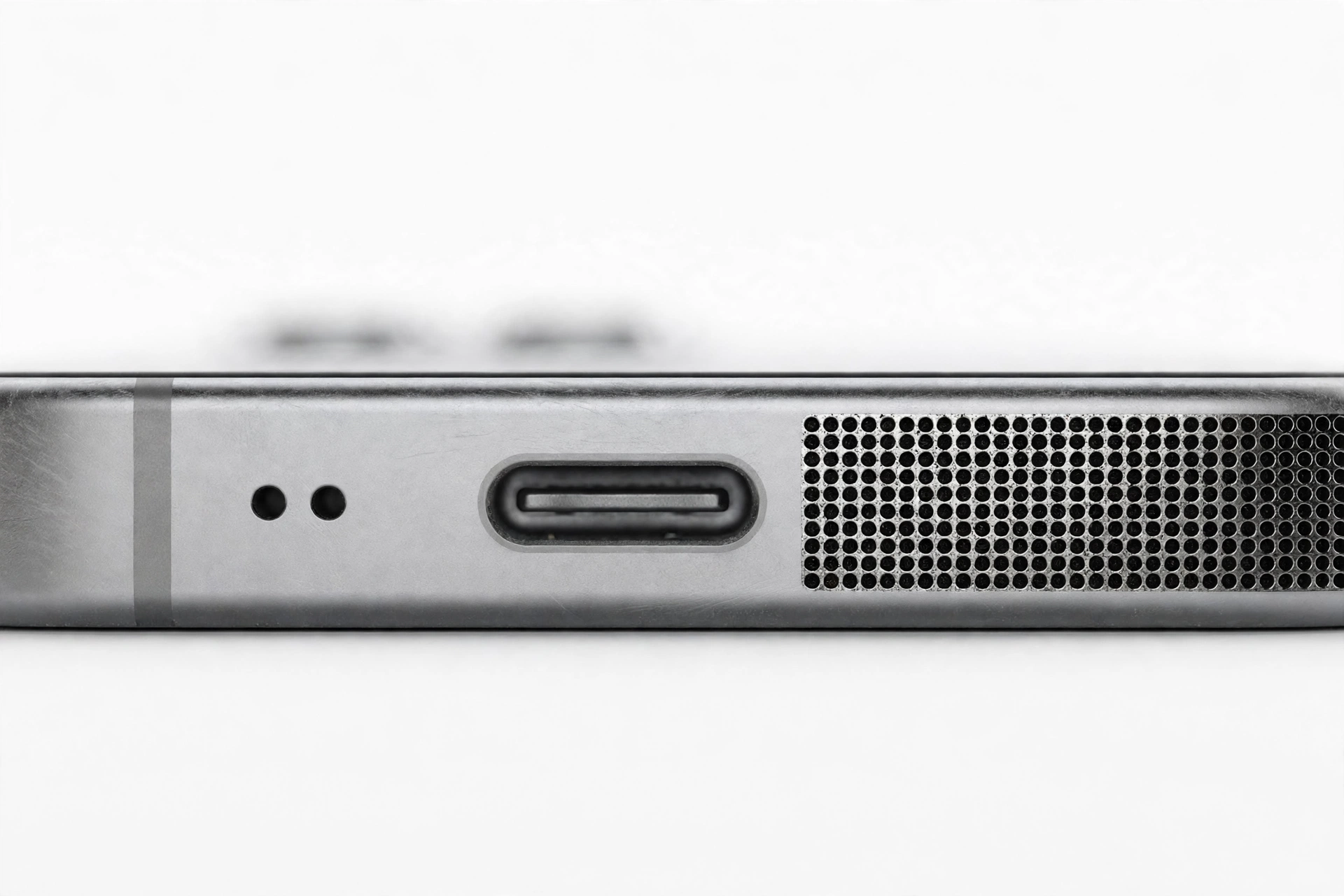 Macro close-up of a smartphone bottom edge speaker grille