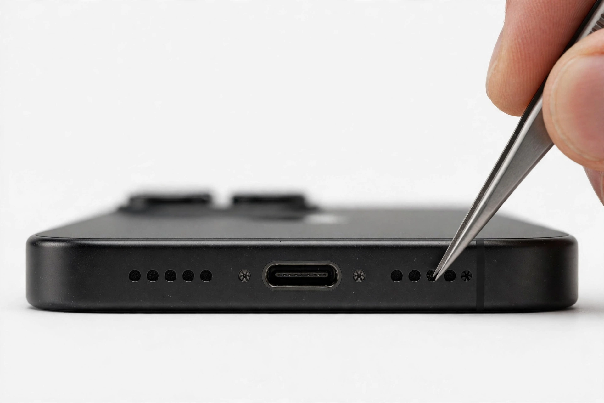 Macro close-up of iPhone bottom edge speaker grille being checked
