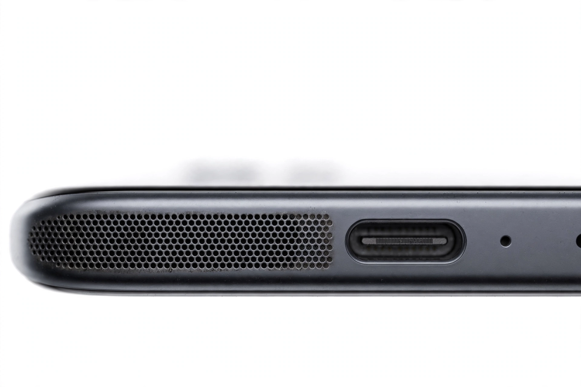 Macro close-up of a smartphone bottom edge speaker grille