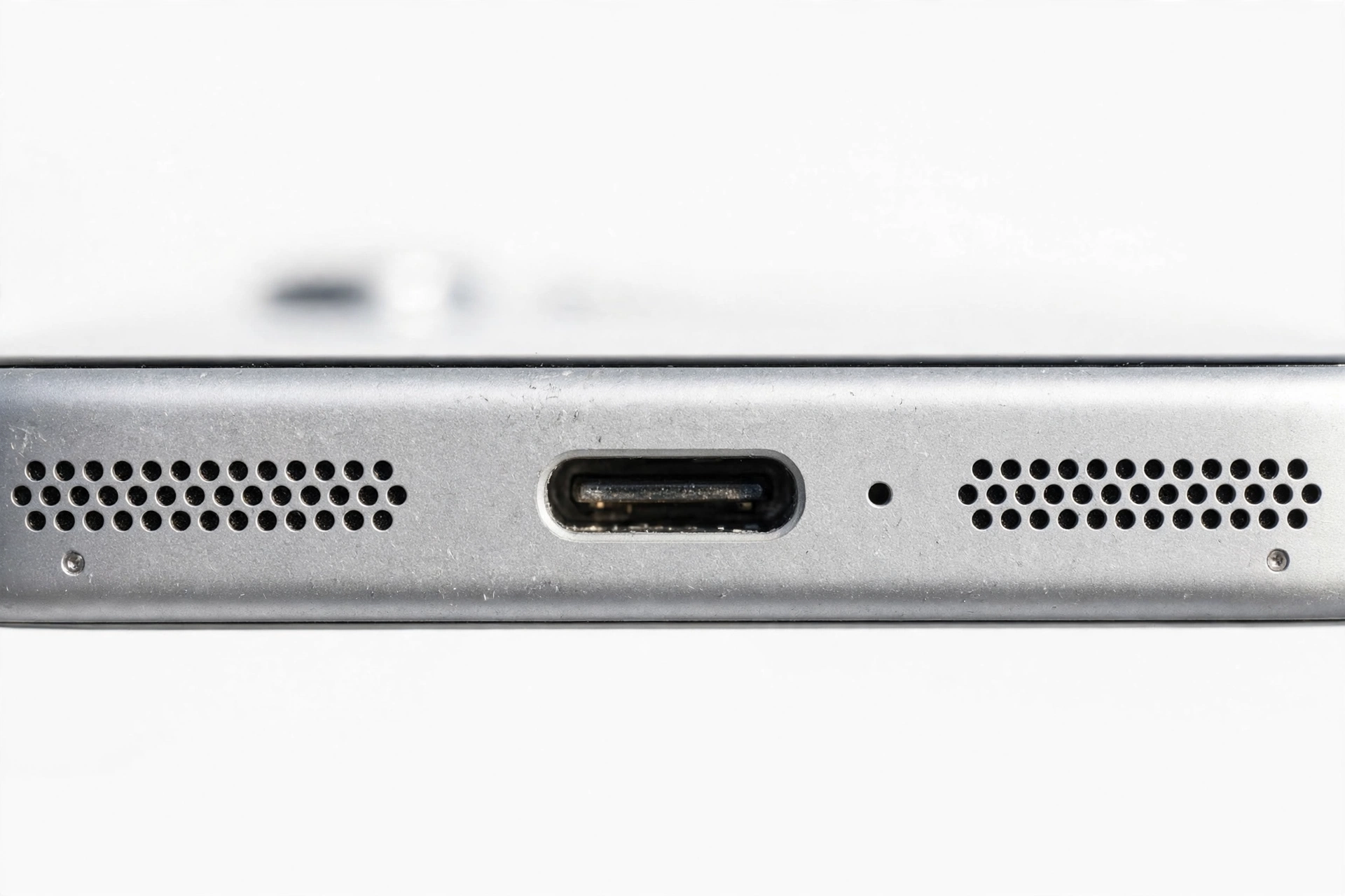 Close-up of a smartphone bottom edge showing the speaker grille
