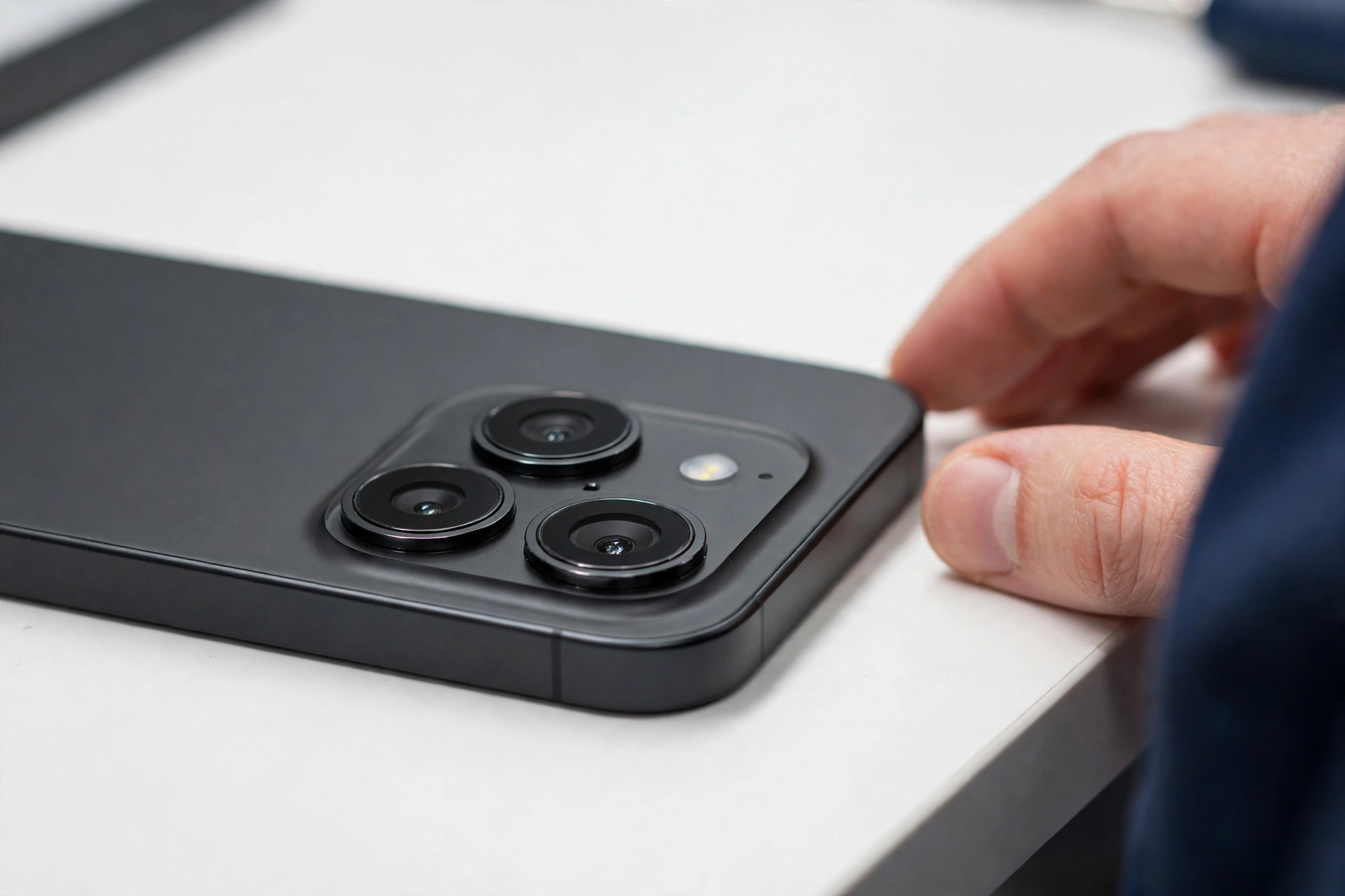 Close-up of a smartphone camera module on a white workbench