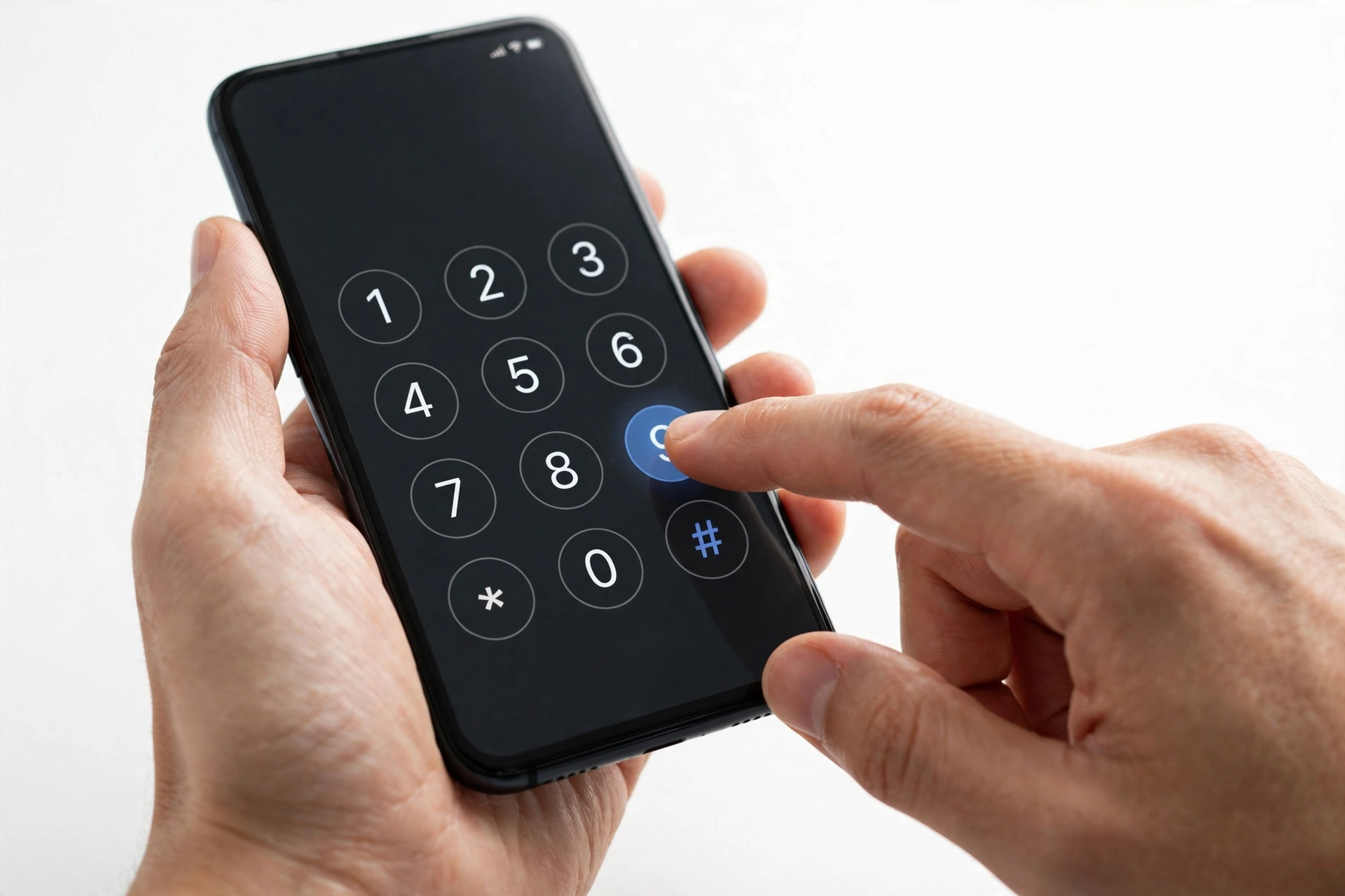 Hands dialing a code on a smartphone to verify IMEI authenticity